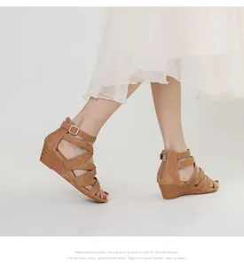 Close-up of camel suede wedge sandals with cross-strap design and buckle ankle strap