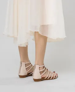 Detail view of pink wedge sandals featuring hollow-out straps and convenient rear zipper