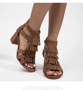 Primer plano de sandalias de gamuza marrón con flecos y tacón ancho de madera