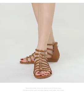 Detail of brown gladiator wedge sandals with metallic bows and back zipper