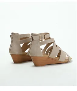 Detail of khaki wedge sandals featuring a gladiator strap design and rear zipper closure