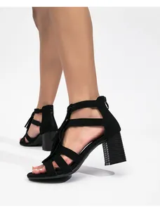 Detalle de sandalias negras de ante con tacón ancho y cremallera trasera estilosa