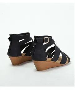 Detail of wedge sandals showing the brown wood-textured heel and rear zipper closure