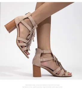Detalle de sandalias de ante color camello con flecos y tacón grueso efecto madera