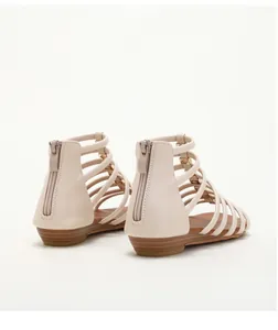 Detail view of beige multi-strap sandals with gold studs and rear zipper closure