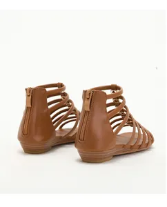 Close-up of brown strappy Roman sandals featuring back zipper and metal rivet details