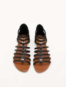 Detail of black gladiator sandals featuring strappy design and rear zipper closure