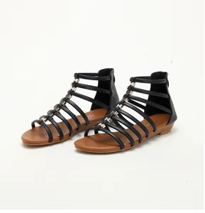 Detail of black gladiator sandals with golden bow accents and back zipper closure