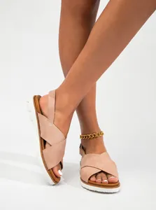 Detalle de sandalias planas beige con tiras cruzadas para mujer y suela antideslizante