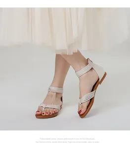 Detail van beige platte sandalen met meerdere bandjes en vetersluiting voor de zomer