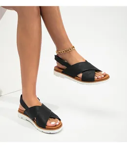 Detalle de sandalias negras de tiras cruzadas con suelas de plataforma dentadas blancas