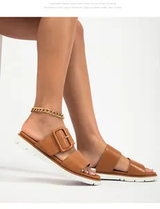 Gros plan de sandales à plateforme marron avec boucle XL et semelle blanche crantée