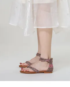 Detail van roze en bruine bandjes met patroon op bohemien enkelband sandalen