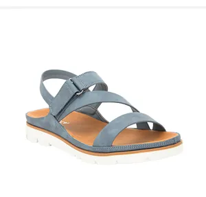 Detalle de sandalias de cuña azul grisáceo con tira ajustable en el talón y suela blanca gruesa