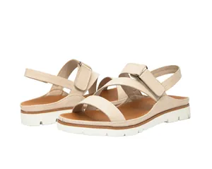 Detalle de los cierres de velcro y la suela blanca de estas sandalias beige