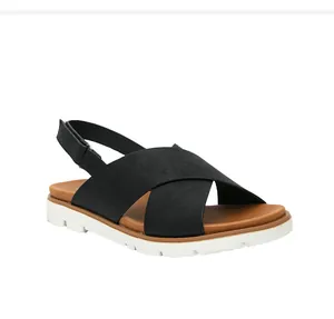 Detalle de sandalias negras de tiras cruzadas con velcro y plataforma blanca dentada