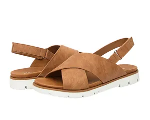 Detalle de sandalias marrones de mujer con tiras cruzadas y suela dentada blanca