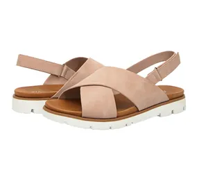 Detalle de las correas cruzadas de ante rosa y el cierre de velcro en sandalias de mujer