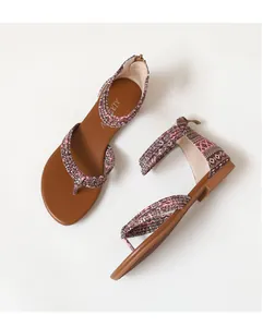 Detail van bohemien platte sandalen met geometrische stoffen bandjes en enkelbandjes