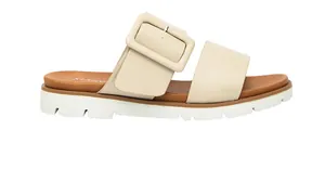 Détail de sandales beiges à semelles compensées avec grande boucle et semelles antidérapantes