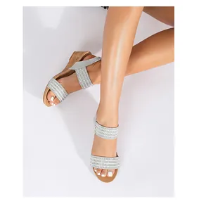 Vista superior de sandalias de cuña plateadas con tiras de strass en una modelo