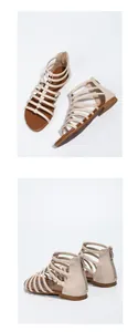 Detail of beige bohemian flat sandals featuring metallic studs and a rear zipper closure
