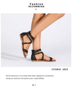 Detail van zwarte platte sandalen met kriskras bandjes en ritssluiting aan de achterkant