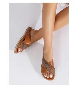 Detalle de sandalias de cuero sintético marrón con brillantes diamantes de imitación