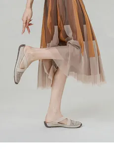 Detailed close-up of beige mesh slip-on shoes with floral embroidery and sequins