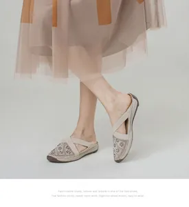 Detail view of beige mesh mule slippers with rhinestone accents and elastic cross straps