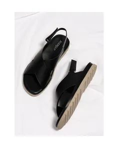 Detailed top view of black cross-strap sandals featuring textured leather and rubber soles