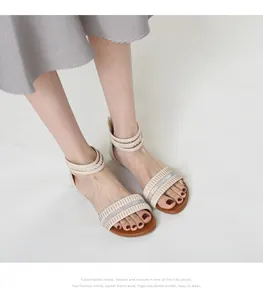 Detail view of beige wedge sandals featuring pleated rhinestone straps and woven ankle ties
