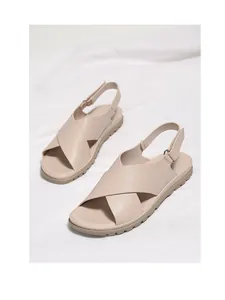 Detail of beige summer sandals with cross straps and non-slip serrated soles