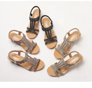 Detailed view of women's wedge sandals in black, taupe, and gold with rhinestone straps