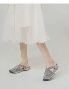Detail of grey mule sneakers featuring sparkling rhinestones and elastic cross straps
