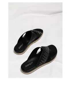 Detalle macro de sandalias negras de tiras cruzadas con adornos de diamantes de imitación