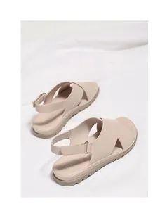 Detail of beige cross-strap sandals with metallic buckle and anti-slip thick sole