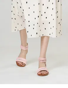 Detail of pink strappy sandals with pleated band and woven ankle wrap on model