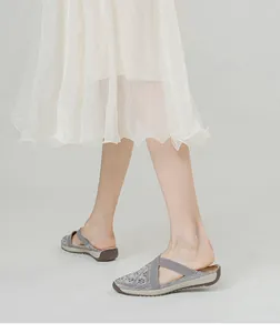 Detail of breathable grey mesh slip-on shoe with elastic criss-cross straps and thick sole