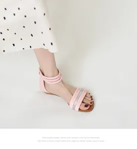 Close-up of pink wedge sandal with sparkling rhinestone strap and woven ankle detail