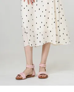 Detail of pink strappy wedge sandals featuring sparkling rhinestones and elegant fringe