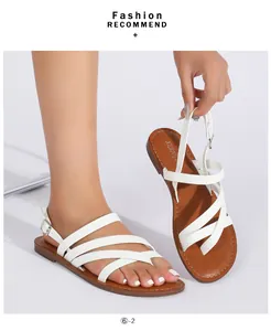 Detail view of white strappy flat sandals with adjustable ankle buckle and brown padded insole