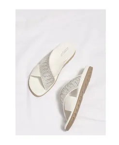 Detalle de sandalias con tiras cruzadas con diamantes de imitación y cuero sintético
