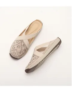 Detail of beige slip-on shoes with rhinestone flower pattern and elastic cross straps
