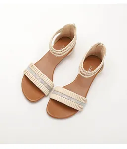 Detail of wedge sandals featuring rhinestone pleats and woven ankle straps with back zipper