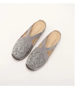 Detail of grey woven mule sandals with sparkling floral rhinestones and elastic cross straps