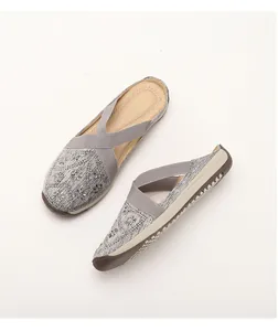 Close-up of grey slip-on mule with snowflake rhinestone patterns and elastic straps
