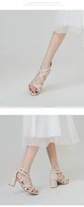 Detalle de sandalias rosas de tacón bloque con tiras cruzadas y cremallera posterior