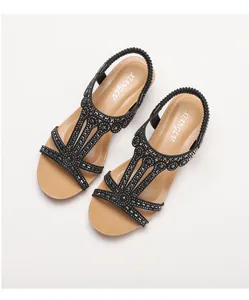 Macro detail of wedge sandals featuring rhinestone crisscross straps and elastic back