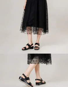 Details von schwarzen Plateau-Sandalen mit Keilabsatz und Doppelriemen am Modell